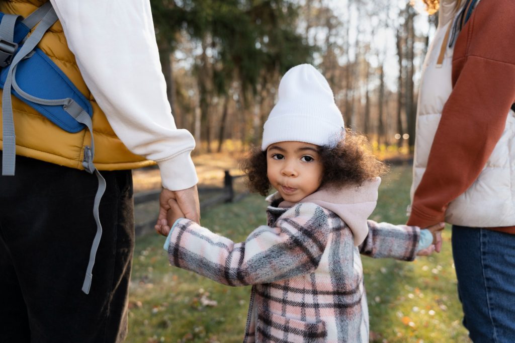 A child holding hands with two parents