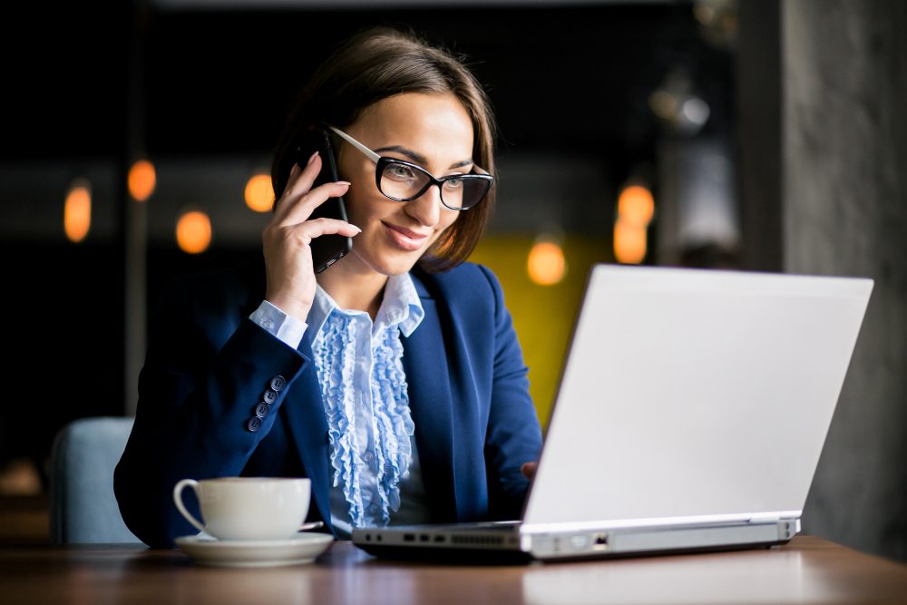 Professional woman lawyer consulting on the phone while working on a laptop in an office